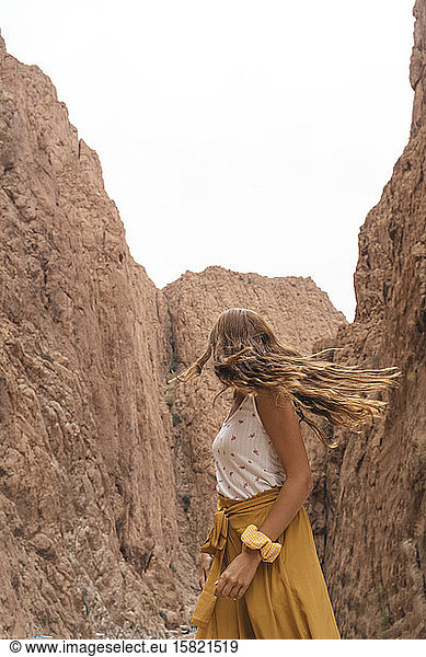 Junge Frau betrachtet Felsen  die ihr den Kopf drehen  Ouarzazate  Marokko