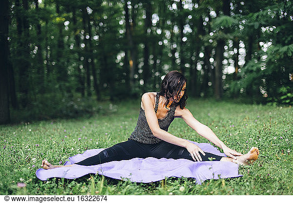 Junge Frau  die sich in der Natur ausstreckt  Yoga in der Natur