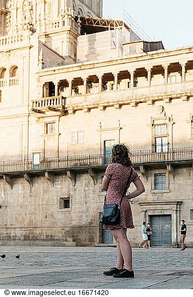 Junge Frau  die wegschaut  während sie auf dem alten Stadtplatz steht