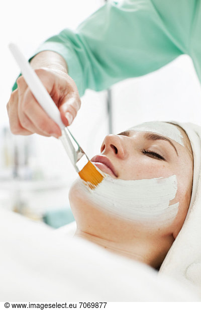 Junge Frau erhält eine Gesichtsbehandlung von der Kosmetikerin im Beauty Spa