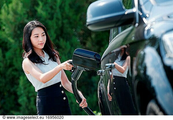 Junge Frau hält eine Waffe für Autobatterie