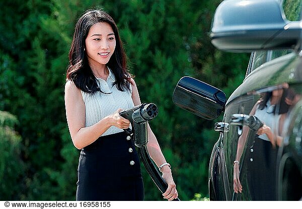 Junge Frau hält eine Waffe für Autobatterie