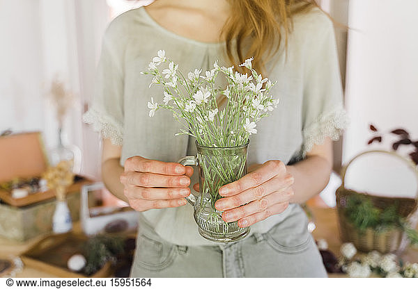 Junge Frau hält Vase mit frischen Blumen