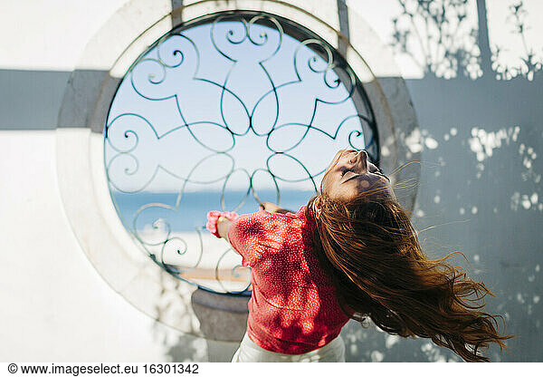 Junge Frau hängt am Fenstergitter in der Alfama  Lissabon  Portugal