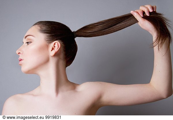 Junge Frau  Haare im Pferdeschwanz  Haare nach oben ziehend