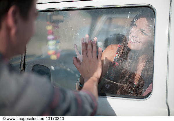 Junge Frau im Fahrzeug  Mann berührt Fenster