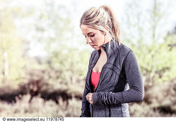 Junge Frau in ländlicher Umgebung  Sweatshirt mit Reißverschluss