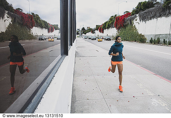 Junge Frau joggt auf Fußweg
