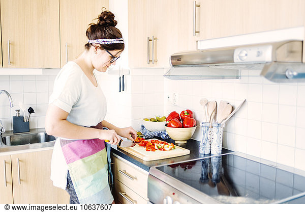 junge Frau junge Frauen Küche rot Peperoni hacken Glocke Tresen