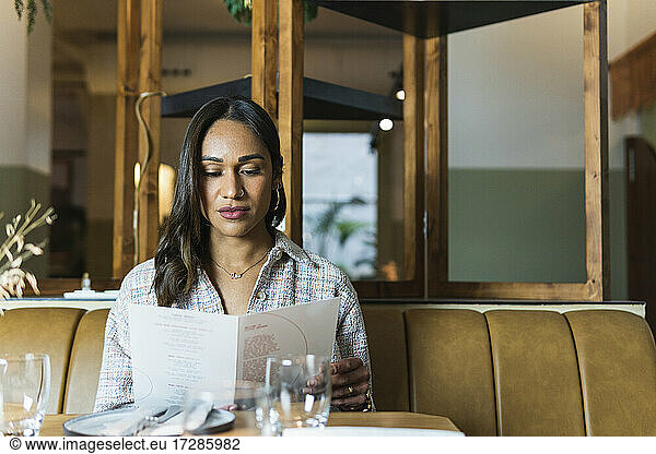 Junge Frau liest Speisekarte im Restaurant