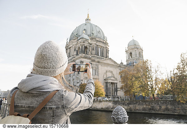 Junge Frau macht ein Smartphone-Foto vom Berliner Dom  Berlin  Deutschland