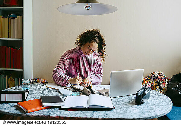 Junge Frau macht Hausaufgaben am Tisch
