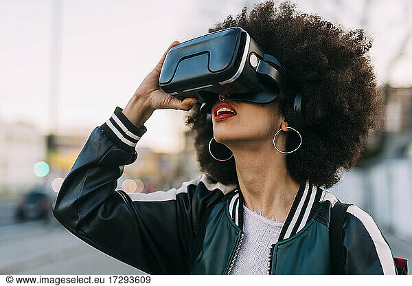 Junge Frau mit Afrofrisur und Virtual-Reality-Headset