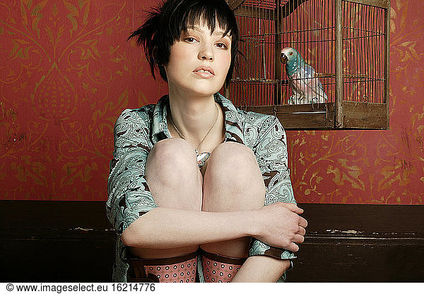 Junge Frau mit Papagei im Käfig  Porträt  Retro-Stil