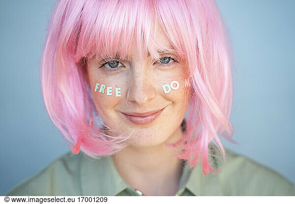 Junge Frau mit rosa Perücke  Buchstaben im Gesicht  Freiheit