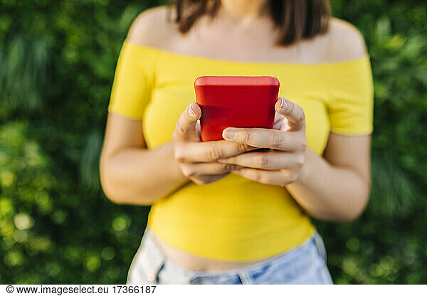 Junge Frau mit rotem Smartphone