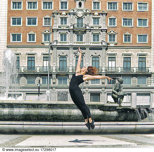 Junge Frau posiert in der Stadt  akrobatisches Konzept
