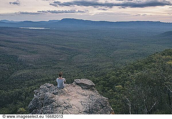 Junge Frau sitzt auf den Balkonen und bewundert die weite Landschaft des Grampians National Park  Victoria  Australien