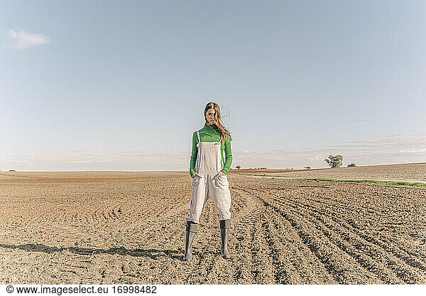 Junge Frau steht auf einem trockenen Feld
