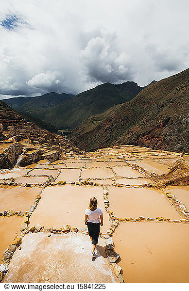 Junge Frau steht in der Nähe der berühmten Salzminen in Peru