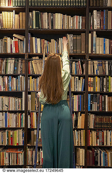 Junge Frau sucht Buch in Bibliothek