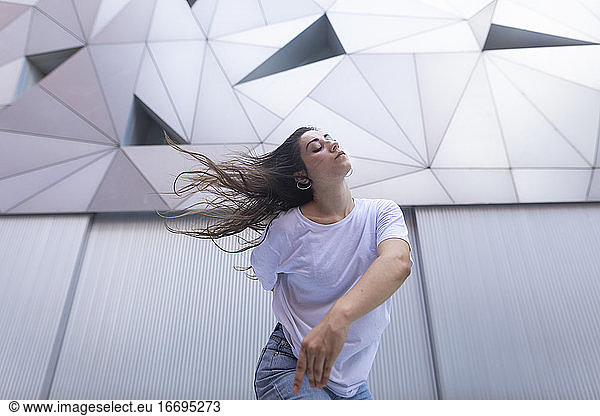 Junge Frau tanzt mit Leidenschaft und Energie auf der Straße