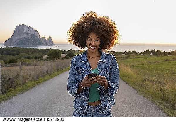 Junge Frau unterwegs mit Smartphone  Ibiza