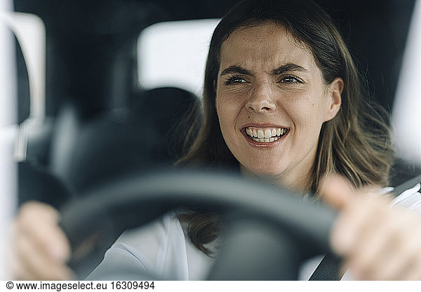 Junge Frau wird wütend  während sie im Verkehr feststeckt