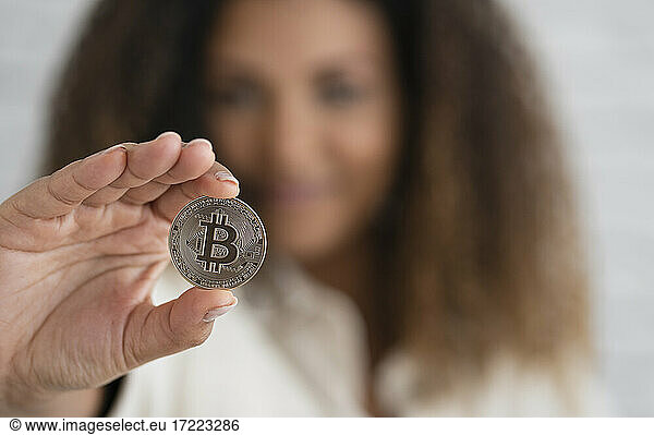 Junge Frau zeigt Silber-Bitcoin