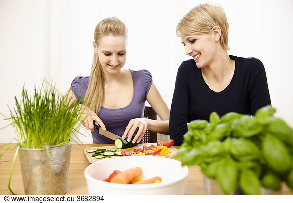 Junge Frauen beim Zubereiten von Speisen  Essen und Trinken