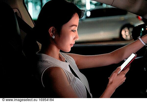 Junge Frauen benutzen ein Mobiltelefon im Auto