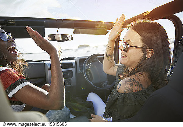 Junge Frauen Freunde High-fiving in sonnigen Jeep  genießen Road Trip