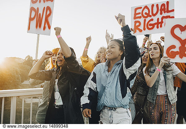 Junge Frauen schreien  während sie für gleiche Rechte gegen den Himmel protestieren