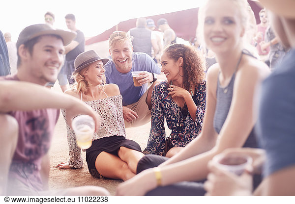 Junge Freunde beim Bier trinken und beim Musikfestival plaudern