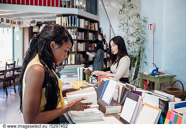 Junge Geschäftsfrauen stöbern in Büchern im Buchladen