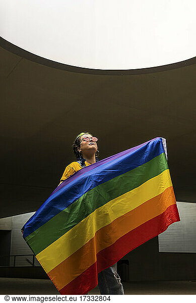 Junge Hipster-Frau hält Regenbogenflagge