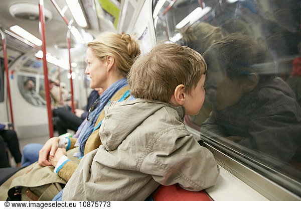 Junge im U-Bahn-Wagen  Gesicht gegen Fenster