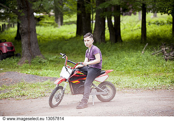 Junge in voller Länge auf einem Geländefahrrad sitzend
