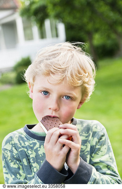 Junge isst Eis im Freien