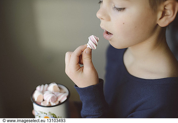 Junge isst Marshmallow zu Hause