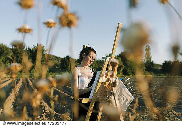 Junge Künstlerin malt auf Staffelei