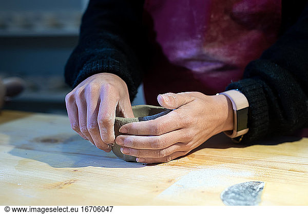 Junge Keramikerin beim Formen einer Keramikschale in einer Töpferwerkstatt