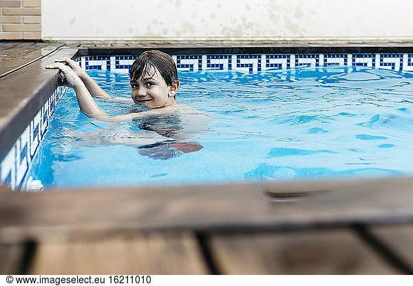 Junge lernt am Pool schwimmen
