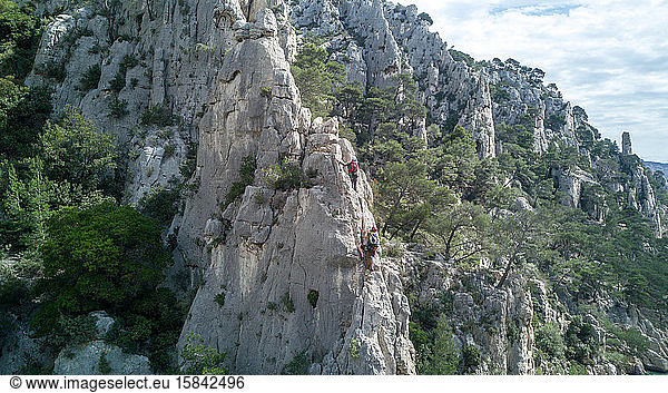 Junge Leute besteigen eine Felsformation im Süden Frankreichs