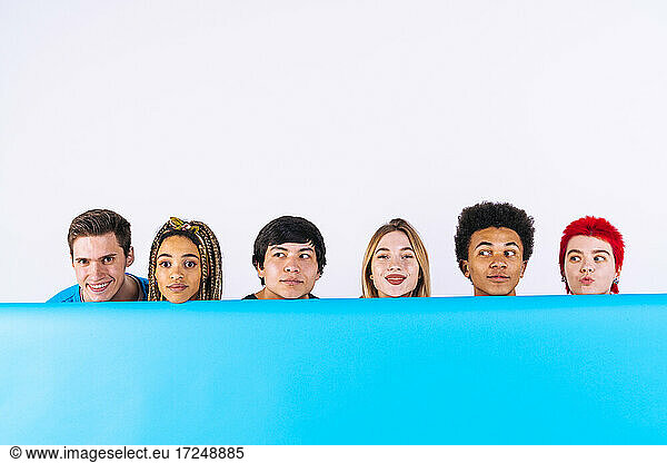 Junge Männer und Frauen hinter blauem Hintergrund auf weißem Hintergrund