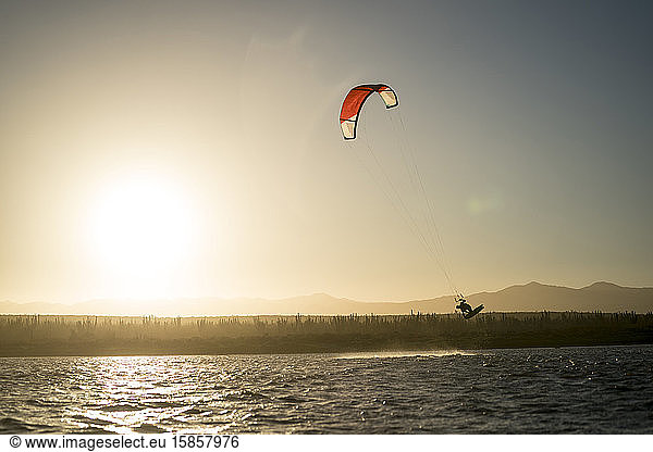 Junge männliche Athleten beim Kitesurfen bei Sonnenuntergang in La Ventana  Baja California  Mexiko