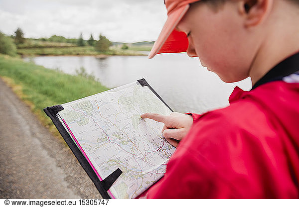 Junge mit Blick auf Karte  Cairngorms  Schottland  UK