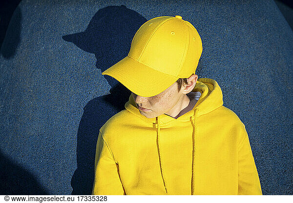 Junge mit gelber Mütze und Sweatshirt im Skateboardpark