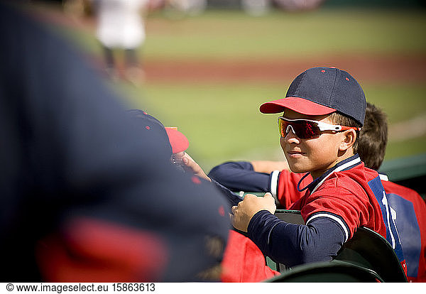 Junge mit Sonnenbrille und Grinsen in Baseball-Uniform