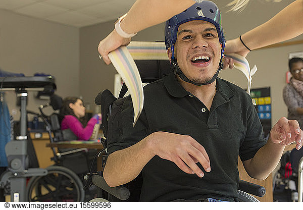 Junge mit spastischer Tetraplegie und Zerebralparese benutzt seinen Helm und den Gurt